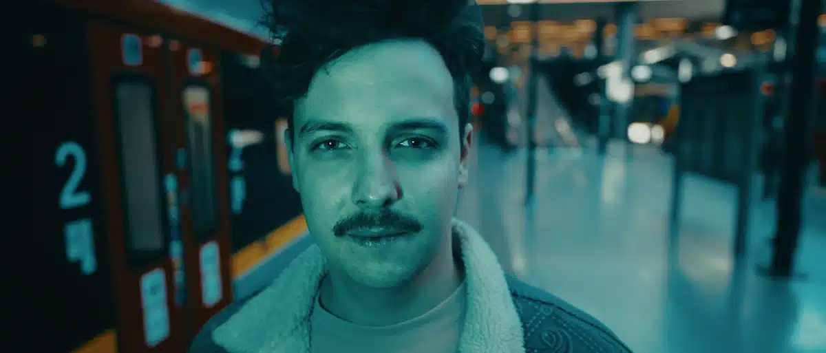 Film promujący wydarzenie Igrzyska Wolności 1 Michał Liszcz na peronie metra. Portret mężczyzny z krótką brodą na tle oświetlonych wagonów. Produkcja filmowa Motion Pikczer Warszawa.