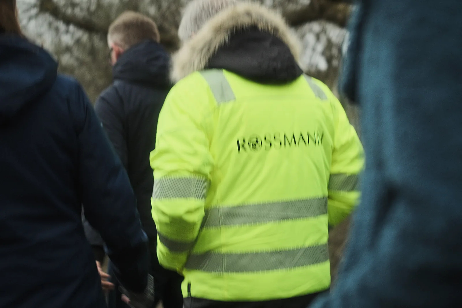 Filmy korporacyjne 3 Pracownik w odblaskowej kamizelce Rossmann na plenerze, kadr z produkcji korporacyjnej.