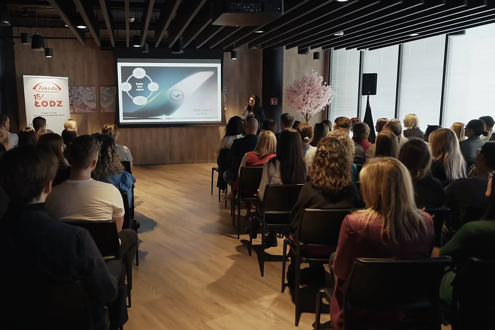 Filmy szkoleniowe 5 Uczestnicy szkolenia w nowoczesnej sali konferencyjnej, kadr z produkcji filmowej.