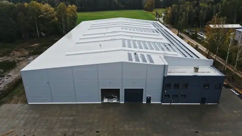 Explainer przed spotkaniem sprzedażowym B2B 5 Ujęcie z drona: biała hala przemysłowa na tle lasu