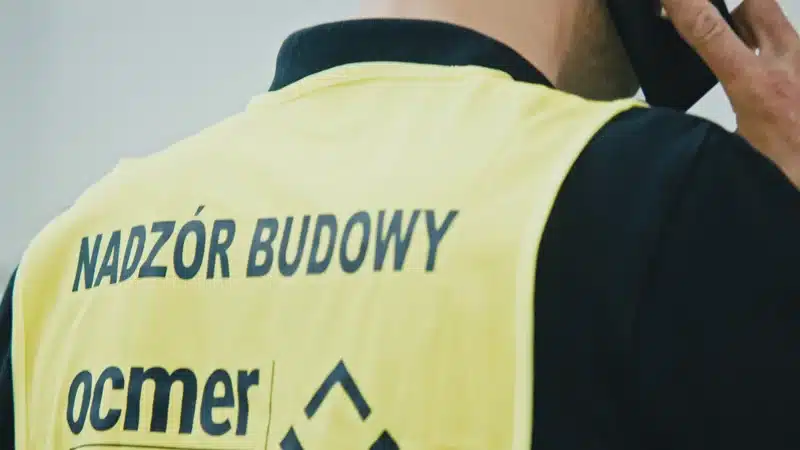 Explainer przed spotkaniem sprzedażowym B2B 8 Osoba w kamizelce z napisem nadzór budowy rozmawia przez telefon