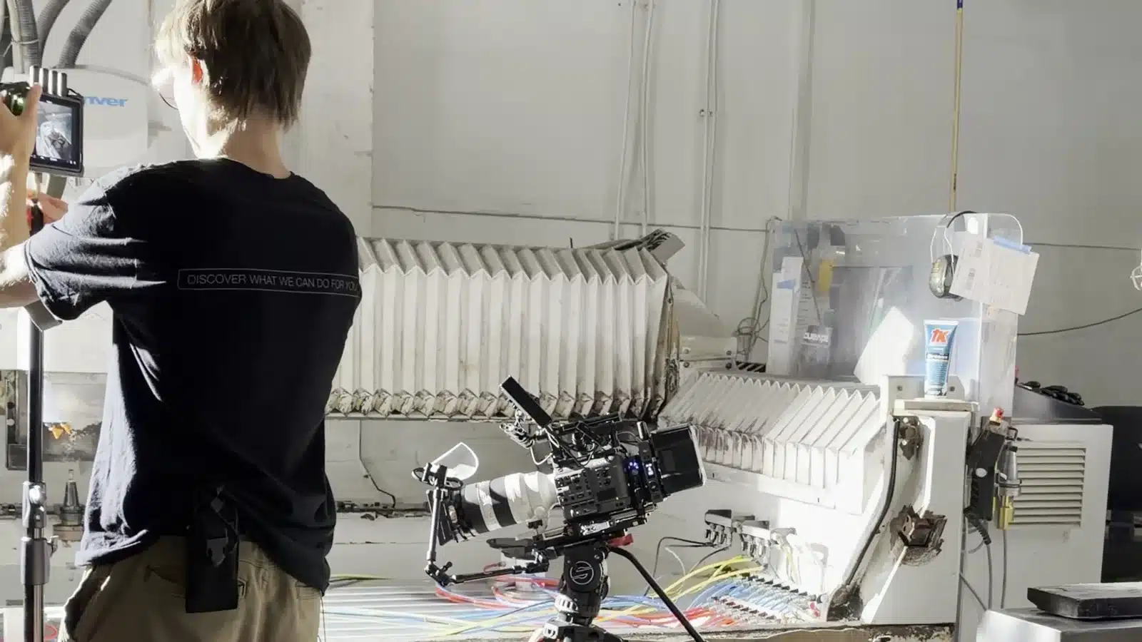 Gotowy scenariusz filmu? Audyt w pięciu punktach 2 Kamera na statywie i osoba przy monitorze podglądowym na planie w hali produkcyjnej