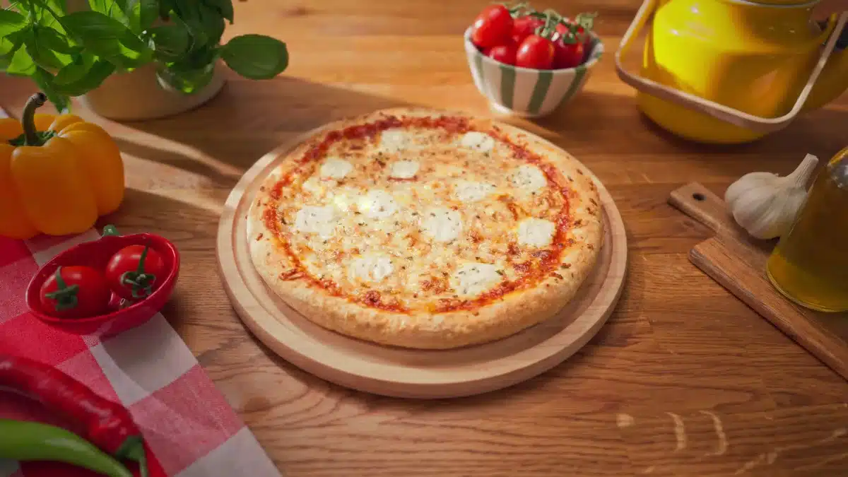Packshot pizzy cztery sery na drewnianej desce w kuchennej scenografii